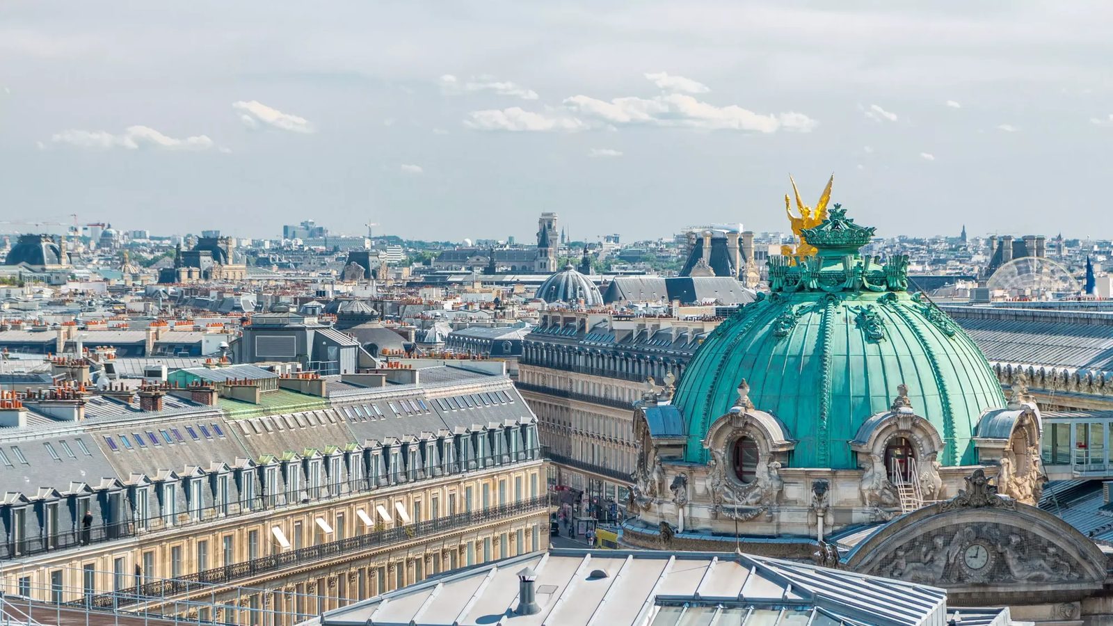 La coupole verte et la statue dorée de l'Opéra Garnier au-dessus des toits du 9e arrondissement de Paris