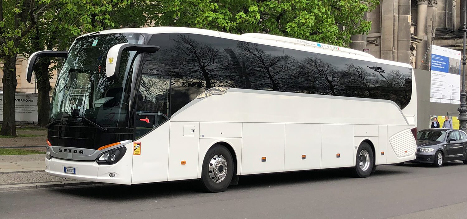 Autocar Setra blanc stationné devant un monument historique, pour un groupe pris en charge dans le 1er arrondissement de Paris